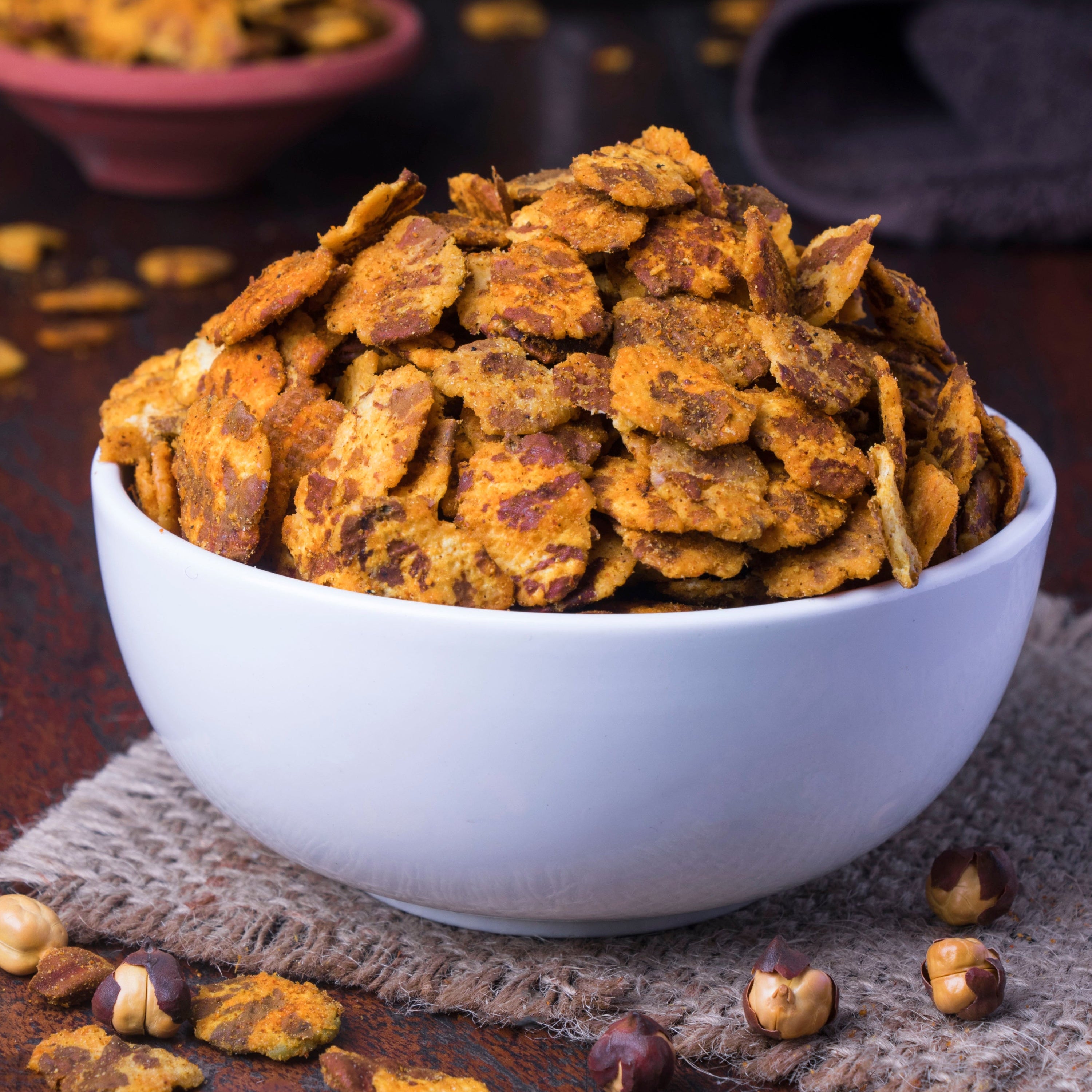 Bowl of roasted cereal grains on a textured surface with blurred background
